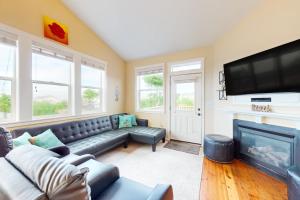 a living room with a couch and a flat screen tv at The Yellow Rose House in Lincoln City