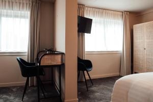 a hotel room with a bed and a table and chairs at Hotel bij Jacob in Enschede