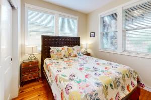 a bedroom with a bed and two windows at The Yellow Rose House in Lincoln City