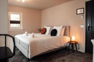 a bedroom with a bed with two cats on it at Boetiek hotel bij Jacob in Enschede