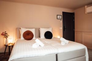 a bedroom with a large white bed with pillows on it at Boetiek hotel bij Jacob in Enschede