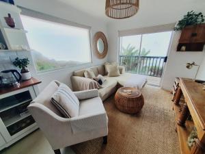 a living room with a couch and a table at Cottage On the Beach in Umdloti