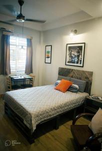 a bedroom with a bed with an orange pillow on it at Deluxe Room have Balcony D1-Dakao in Ho Chi Minh City