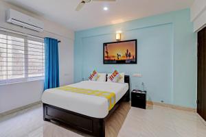 1 dormitorio con 1 cama con pared azul en OYO Nr Royal en Bangalore