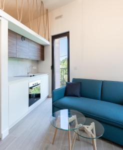 a living room with a blue couch and a glass table at Tivat lovely cosy studio in Tivat