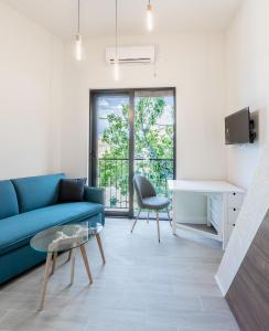 ein Wohnzimmer mit einem blauen Sofa und einem Tisch in der Unterkunft Tivat lovely cosy studio in Tivat
