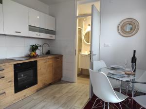 eine Küche mit einem Glastisch und weißen Stühlen in der Unterkunft Apartment Stipčić-Mrežnički Brig in Duga Resa