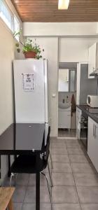 a kitchen with a refrigerator and a table with chairs at Tiny House Funchal in Funchal