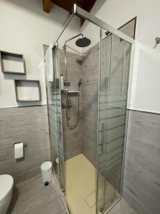 La salle de bains est pourvue d'une douche avec une porte en verre. dans l'établissement Una Casetta InterVineas, à Spolète
