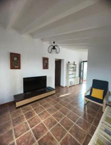 uma sala de estar com televisão e piso em azulejo em Casa Tomas em Albox