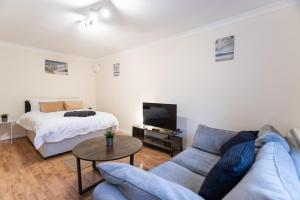 uma sala de estar com um sofá e uma cama em May Disc - Long Stay - Contractors em Bristol