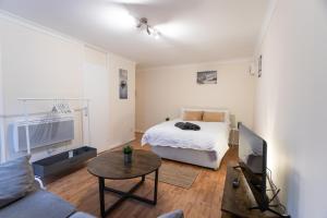 a living room with a bed and a tv at April Disc - Long Stay - Contractors in Bristol