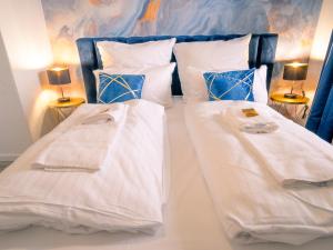 um quarto com 2 camas com lençóis brancos e almofadas em Comfort Suite - Family+Business em Giessen
