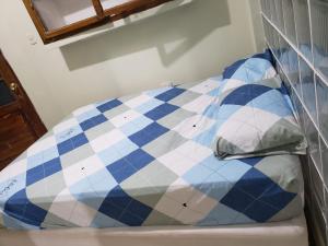 łóżko z niebiesko-białym kocem w obiekcie WAYNA & WAYLLUY w mieście Talara