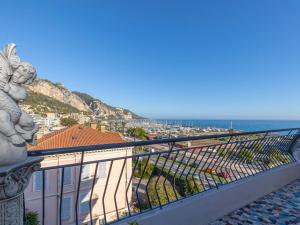 a balcony with a view of a city and the ocean at Appartement Menton, 2 pièces, 4 personnes - FR-1-196-340 in Menton