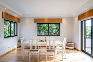 une salle à manger avec une table et des chaises blanches dans l'établissement Oeiras apt in Spacious Villa - Shared Pool, à Oeiras