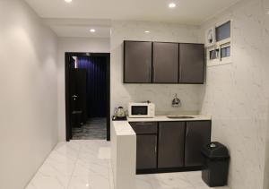 uma cozinha com um lavatório e um micro-ondas em قمم بارك Qimam Park Hotel 1 em Abha