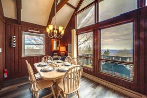 a dining room with a table and chairs and windows at Cozy Mountain-View Escape, 1 Mi to Beech Mountain! in Beech Mountain
