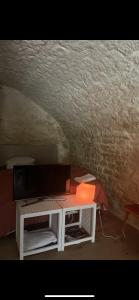 a living room with a tv and a table at Voute des anges type loft sans cloison in Castelnau-Montratier +3 photos
