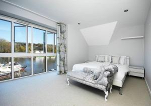 een slaapkamer met een bed en een groot raam bij The Oars - Riverfront Property in Henley on Thames