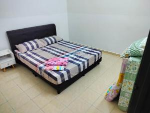 um quarto com uma cama com duas almofadas em Celine's Homestay em Taiping