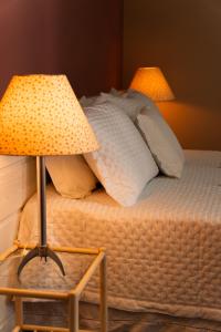cama con almohadas y mesa con lámpara en Cabanas da Lua, en Florianópolis