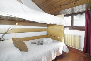 een slaapkamer met een bed met een paraplu en boeken bij iFlat Madonna di Campiglio Penthouse Brenta in Madonna di Campiglio