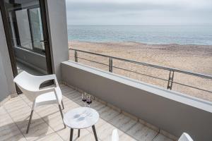 uma varanda com uma mesa e 2 copos de vinho em Beyond Beautiful Beach House em Langstrand