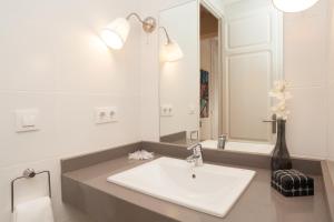 uma casa de banho com um lavatório branco e um espelho. em Lodging Apartments Sagrada Familia em Barcelona