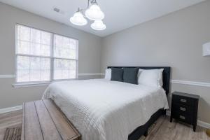 a white bedroom with a bed and a table at Charming Suburb 20 Min to ATL! in Decatur