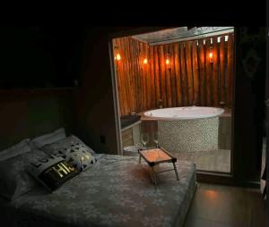 a bedroom with a tub and a bed and a table at Espaço Tranquilum in Sorocaba