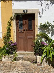 una porta in legno su una casa con fiori di Albergue do Infante a Tomar