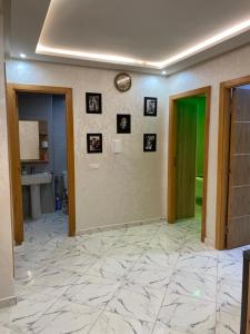 a hallway with a green door and pictures on the wall at Bel appart said hajji in Salé