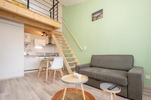 a living room with a couch and a table at Studio mezzanine "chaumiane" proche de la gare in Issoire