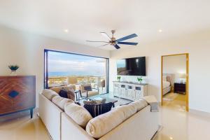 a living room with a large couch and a television at Tramonti Los Cabos C401 Lupos PH in Cabo San Lucas