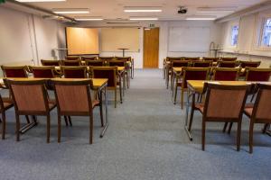 an empty room with tables and chairs in a classroom at Norrfällsviken Rum & Kök in Mjällom