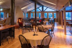 a restaurant with tables and chairs with candles on them at Norrfällsviken Rum & Kök in Mjällom