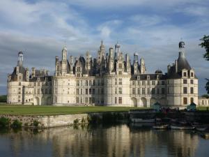 ein großes Schloss mit einem Fluss davor in der Unterkunft Charmante propriété, piscine, Zoo Beauval, Châteaux Loire in Selles-sur-Cher