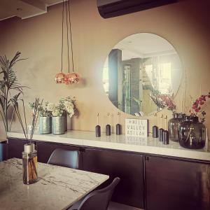 a dining room with a table and a mirror at Hill Valley Asilah - Luxury Living & Boutique Hotel in Asilah