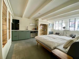 1 dormitorio con 1 cama grande y cocina en This Must Be The Place, en Utrecht
