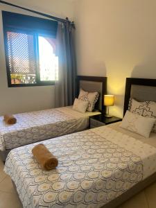 a bedroom with two beds and a window at Appartement Premium Village, 5 piscines in Marrakech