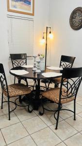 stół jadalny z 4 krzesłami i lampką w obiekcie Departamento familiar Sweet Home w mieście Reynosa