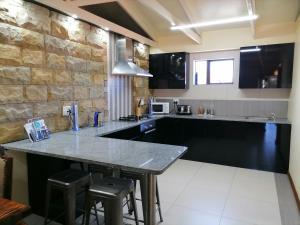 uma cozinha com um grande balcão com bancos em 20 On Percy na Cidade do Cabo