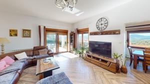 uma sala de estar com um sofá e uma televisão em Sunny Villa in Kavac em Tivat