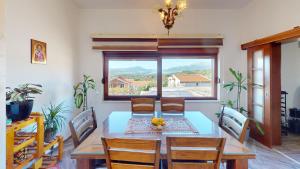 uma sala de jantar com uma mesa e cadeiras e uma janela em Sunny Villa in Kavac em Tivat