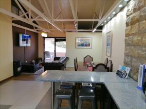 um átrio com um bar com bancos e uma sala de estar em 20 On Percy na Cidade do Cabo