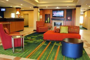eine Lobby mit einem Sofa und Stühlen sowie einem TV in der Unterkunft Fairfield Inn and Suites by Marriott Marion in Marion