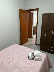 Residencial Wrubleski SC في بينيرا: غرفة نوم بسرير وبطانية وردية