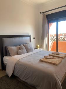 a bedroom with a large bed with towels on it at Appartement Premium Village, 5 piscines in Marrakesh