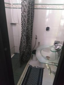 a bathroom with a sink and a shower at Hostel Suite Home in Saquarema